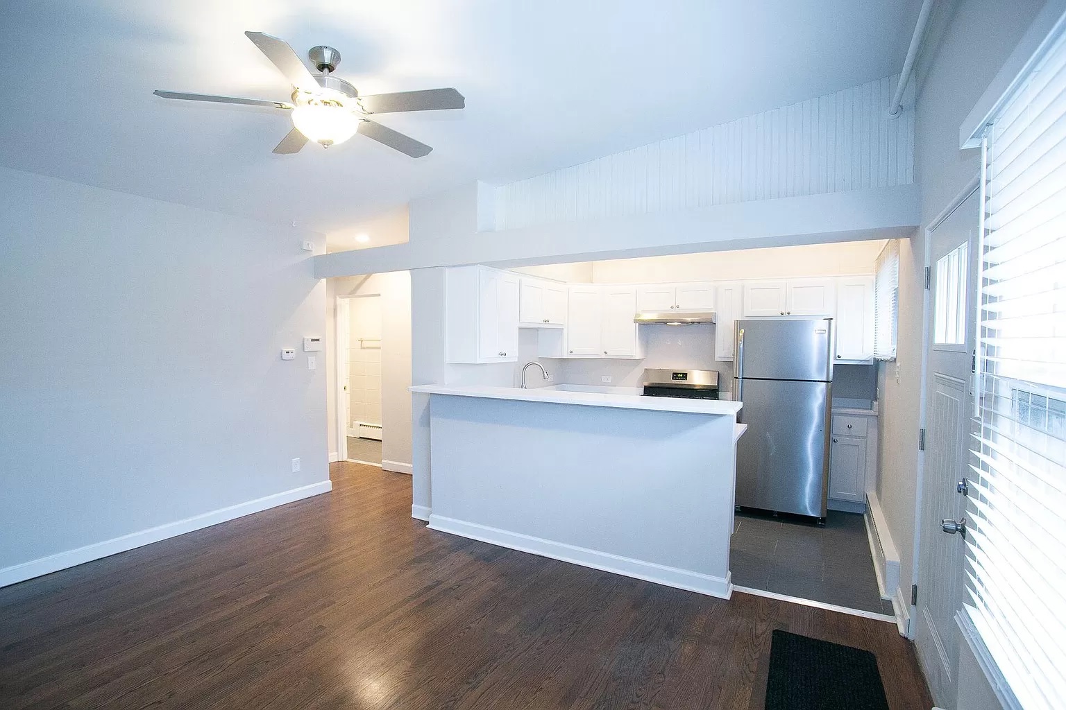 A rooftop barbecue grill on a white counter, set against city buildings.